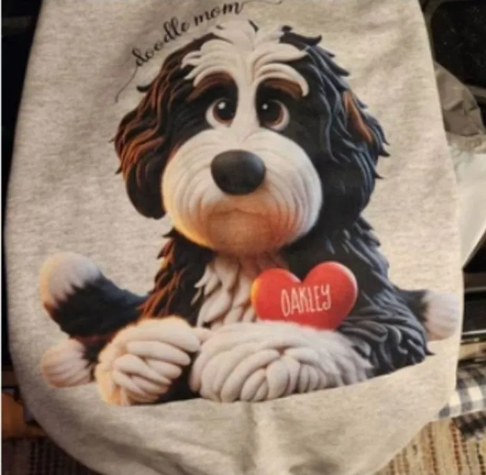 Grey sweatshirt with a Bernedoodle holding a heart that reads Oakley